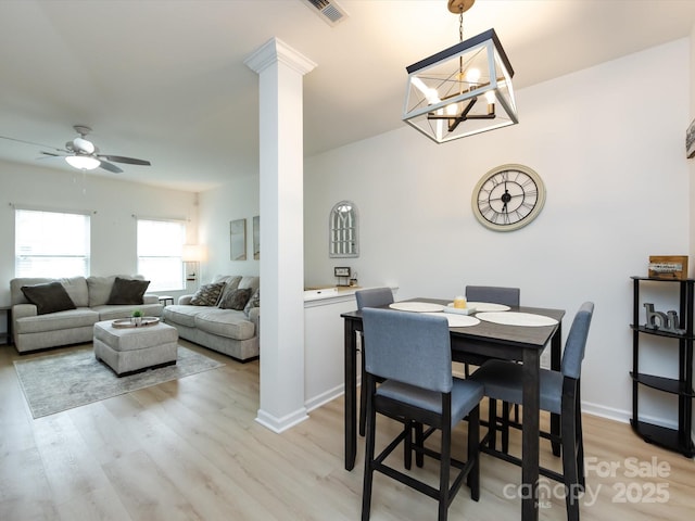 13422 Calloway Glen Dr, Charlotte, NC 28273 - dining space with light wood finished floors, a ceiling fan, ornate columns, and a chandelier