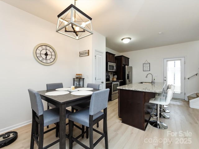 13422 Calloway Glen Dr, Charlotte, NC 28273 - dining area with light wood-style flooring, a chandelier, and baseboards