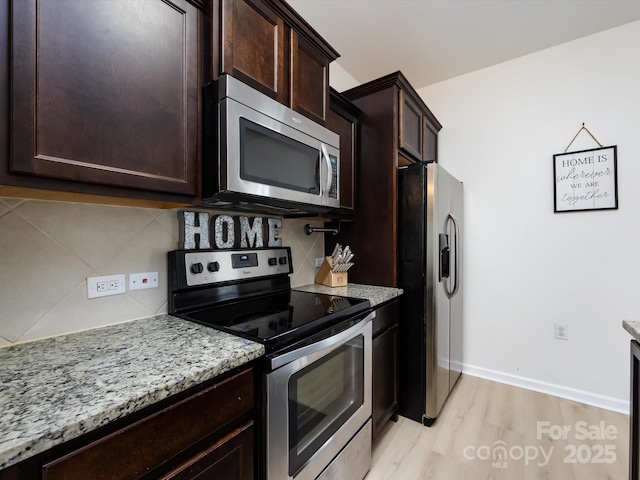 13422 Calloway Glen Dr, Charlotte, NC 28273 - kitchen with stainless steel appliances, light wood-style floors, decorative backsplash, light stone counters, and dark brown cabinets