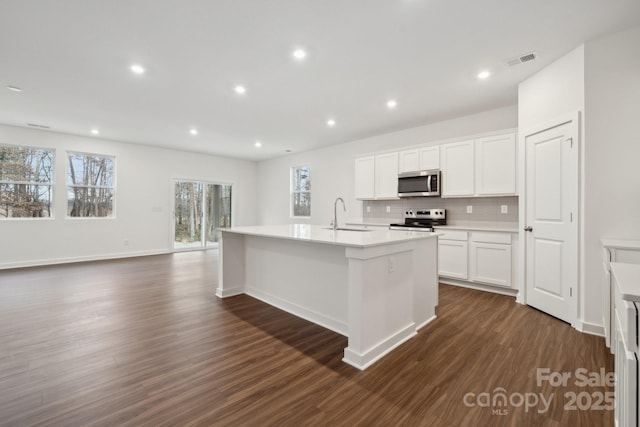 2584 Blue Sky Meadows Dr, Monroe, NC 28110 - kitchen featuring appliances with stainless steel finishes, tasteful backsplash, dark wood finished floors, an island with sink, and recessed lighting