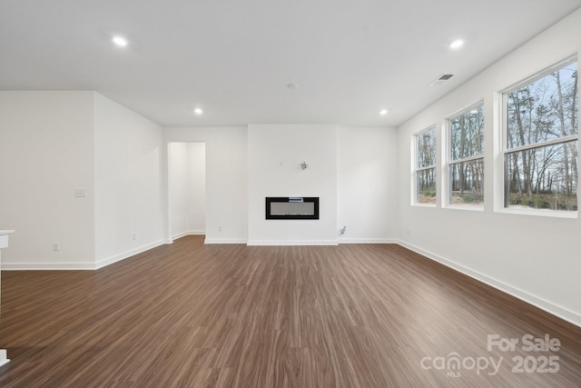 2584 Blue Sky Meadows Dr, Monroe, NC 28110 - unfurnished living room with dark wood-type flooring, recessed lighting, and a glass covered fireplace