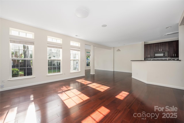 6416 Union Station Ct, Charlotte, NC 28210 - unfurnished living room with dark wood-style flooring and baseboards