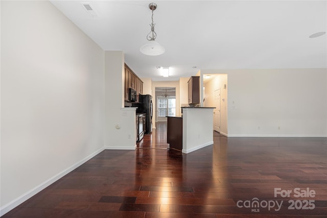 6416 Union Station Ct, Charlotte, NC 28210 - kitchen featuring dark wood-style floors, black appliances, open floor plan, dark countertops, and pendant lighting