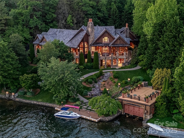 41 Chimney Pt, Lake Toxaway, NC 28747 - rear view of house with a chimney, a wooded view, a lawn, stairway, and a deck with water view