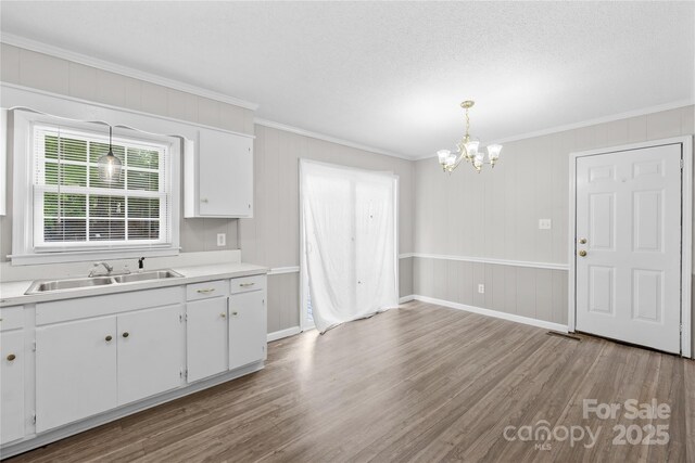 1812 Alpine Dr, Kings Mountain, NC 28086 - kitchen featuring crown molding, a chandelier, light wood-style floors, white cabinetry, and light countertops