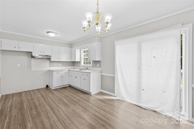 1812 Alpine Dr, Kings Mountain, NC 28086 - kitchen with under cabinet range hood, light wood-type flooring, a chandelier, light countertops, and white cabinets