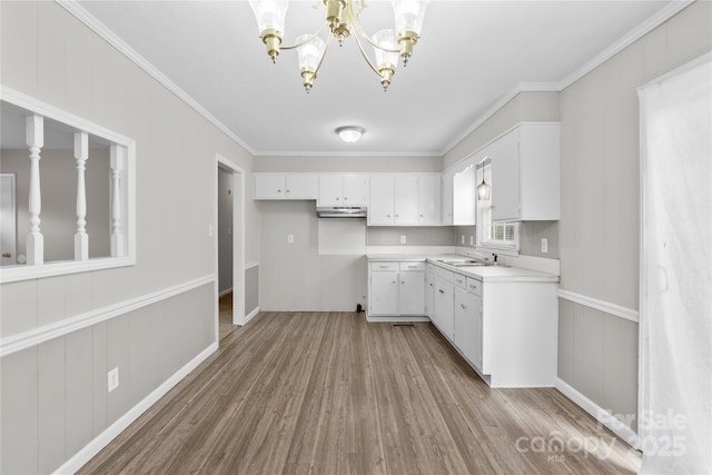 1812 Alpine Dr, Kings Mountain, NC 28086 - kitchen featuring wood finished floors, a chandelier, light countertops, white cabinetry, and crown molding