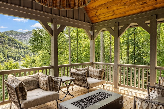 75 Indigo Bunting Ct, Tuckasegee, NC 28783 - deck featuring an outdoor living space with a fire pit, a mountain view, and a view of trees