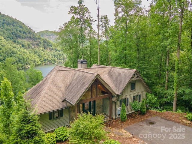 75 Indigo Bunting Ct, Tuckasegee, NC 28783 - chalet / cabin featuring a chimney, a wooded view, a shingled roof, and board and batten siding