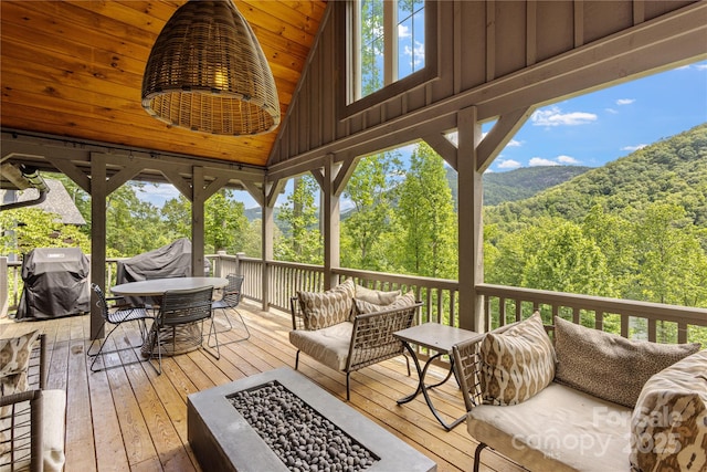 75 Indigo Bunting Ct, Tuckasegee, NC 28783 - wooden terrace featuring an outdoor living space with a fire pit, a grill, a view of trees, and outdoor dining area