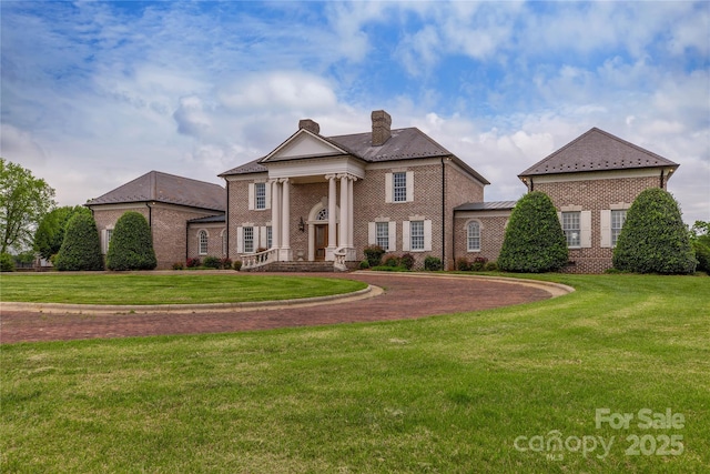 1100 Glen Oaks Dr, Hamptonville, NC 27020 - neoclassical home featuring a chimney, brick siding, and a front yard