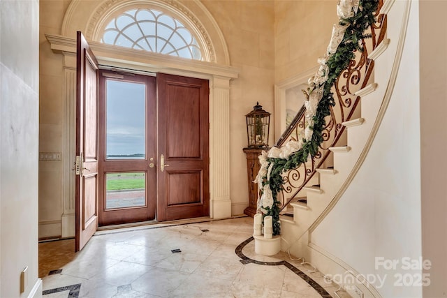 1100 Glen Oaks Dr, Hamptonville, NC 27020 - foyer entrance with inlaid floor details, stairway, a high ceiling, baseboards, and light marble finish flooring