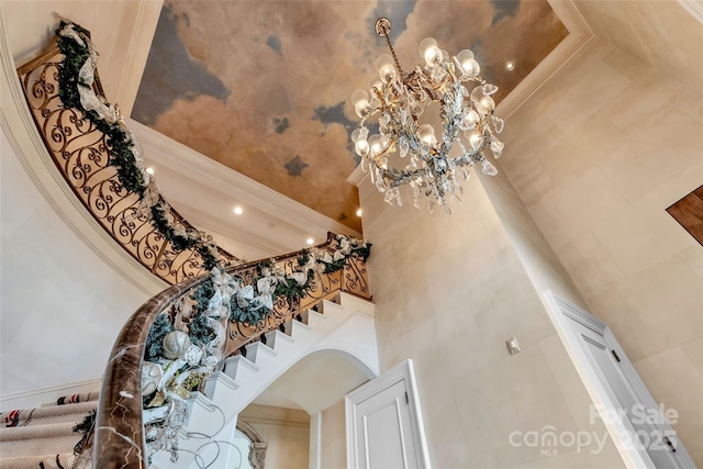 1100 Glen Oaks Dr, Hamptonville, NC 27020 - staircase with a high ceiling, crown molding, a chandelier, and arched walkways
