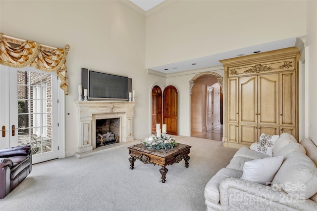 1100 Glen Oaks Dr, Hamptonville, NC 27020 - living room featuring arched walkways, light carpet, a high end fireplace, and crown molding