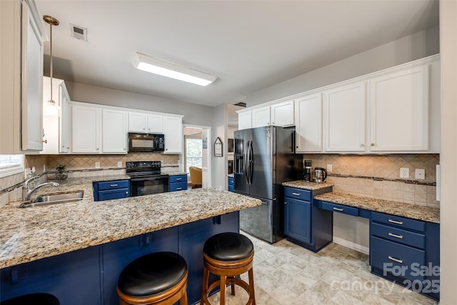 1206 Craig Ave, Lancaster, SC 29720 - kitchen with black appliances, blue cabinetry, a sink, and a breakfast bar area