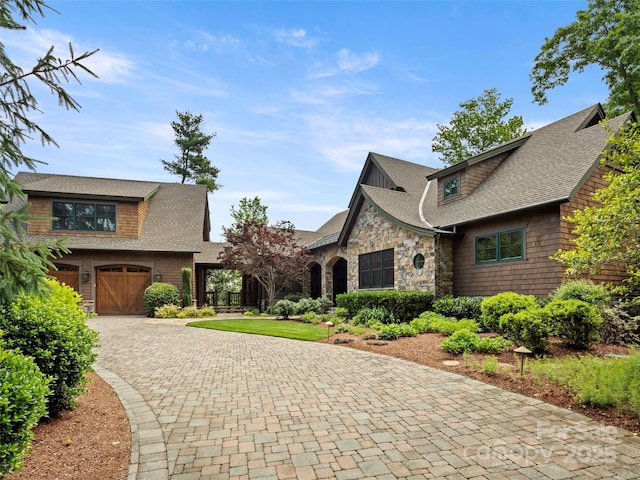 24 Deep Creek Trl, Arden, NC 28704 - view of front of property with a shingled roof, curved driveway, stone siding, and a garage
