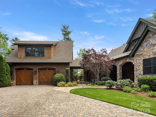 24 Deep Creek Trl, Arden, NC 28704 - view of front facade with stone siding, decorative driveway, roof with shingles, and an attached garage