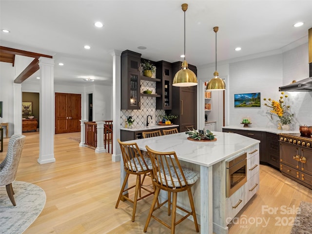 24 Deep Creek Trl, Arden, NC 28704 - kitchen with decorative columns, stainless steel microwave, open shelves, decorative backsplash, and ornamental molding