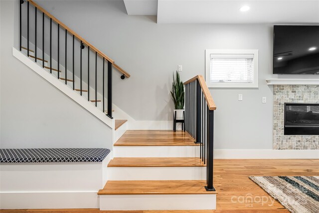 307 Hazel Mill Rd, Asheville, NC 28806 - staircase with wood finished floors, a glass covered fireplace, baseboards, and recessed lighting