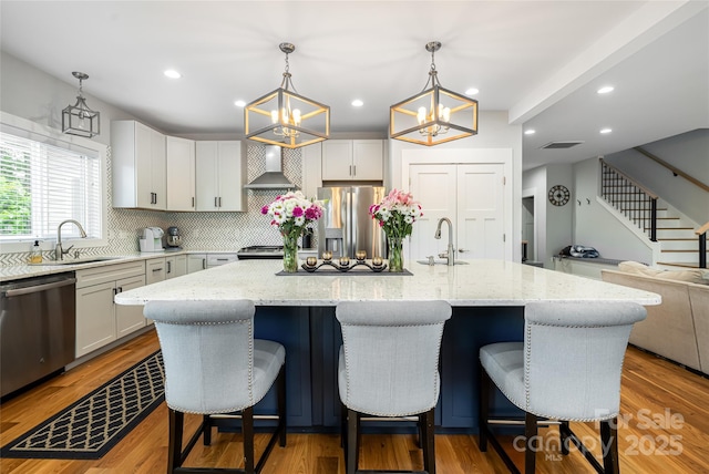 307 Hazel Mill Rd, Asheville, NC 28806 - kitchen with stainless steel appliances, wall chimney exhaust hood, a sink, backsplash, and recessed lighting