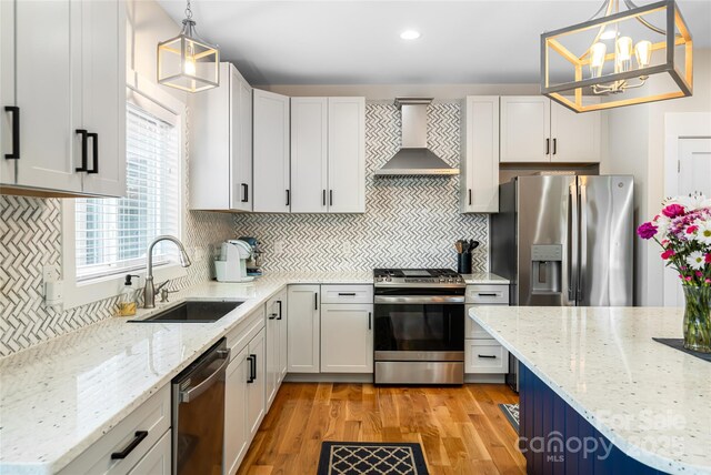 307 Hazel Mill Rd, Asheville, NC 28806 - kitchen with wall chimney exhaust hood, appliances with stainless steel finishes, a sink, light wood-type flooring, and recessed lighting