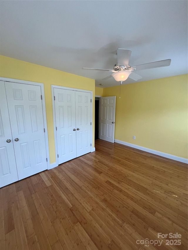 8720 Lee St, Mount Pleasant, NC 28124 - unfurnished bedroom featuring two closets, hardwood / wood-style flooring, and ceiling fan