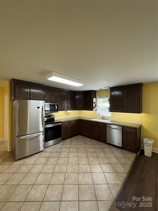 8720 Lee St, Mount Pleasant, NC 28124 - kitchen with appliances with stainless steel finishes, dark brown cabinets, light countertops, and light tile patterned flooring
