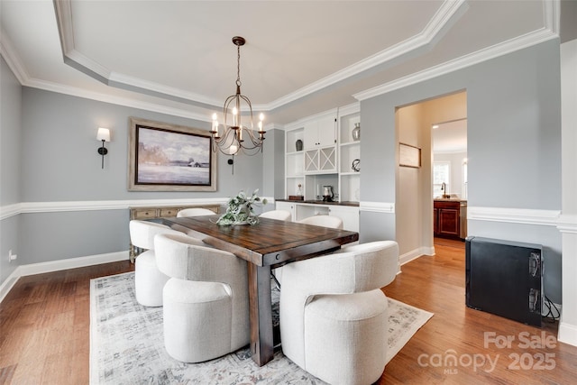 645 Brookhaven Dr, Fort Mill, SC 29708 - dining space with a chandelier, wood finished floors, ornamental molding, a tray ceiling, and baseboards