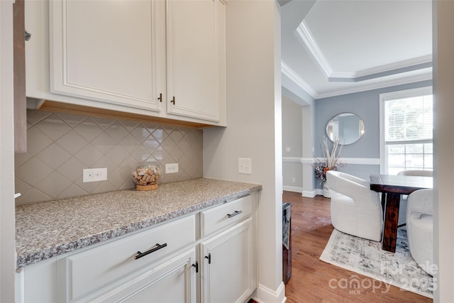 645 Brookhaven Dr, Fort Mill, SC 29708 - kitchen featuring crown molding, a raised ceiling, wood finished floors, tasteful backsplash, and white cabinetry