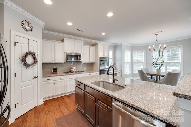 645 Brookhaven Dr, Fort Mill, SC 29708 - kitchen featuring stainless steel appliances, a sink, light wood-style flooring, white cabinetry, and backsplash