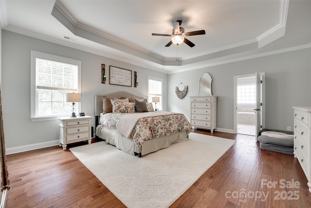 645 Brookhaven Dr, Fort Mill, SC 29708 - bedroom featuring a tray ceiling, multiple windows, wood finished floors, crown molding, and baseboards
