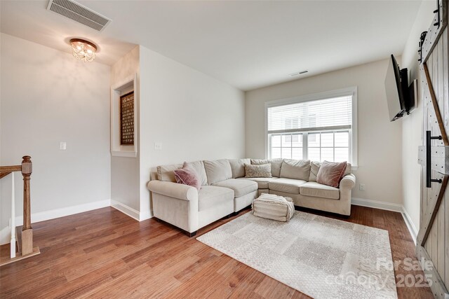 645 Brookhaven Dr, Fort Mill, SC 29708 - living room featuring a barn door, wood finished floors, and baseboards