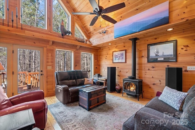 650 Mcdowell Rd, Columbus, NC 28722 - living room featuring a wood stove, wood walls, light wood-style flooring, ceiling fan, and high vaulted ceiling