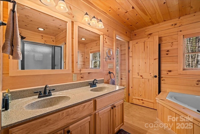 650 Mcdowell Rd, Columbus, NC 28722 - bathroom with wood walls, a shower stall, double vanity, a bath, and wood finished floors