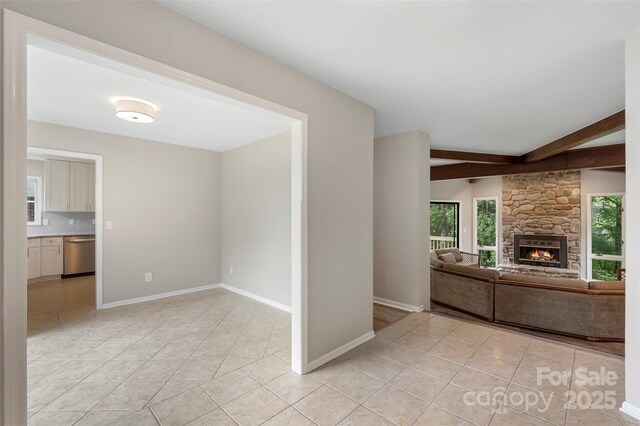 2666 Providence Dr, Gastonia, NC 28052 - unfurnished living room featuring light tile patterned flooring, beamed ceiling, a fireplace, and baseboards