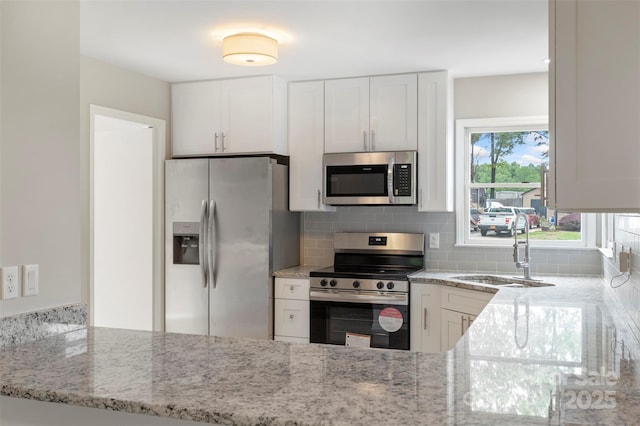 2666 Providence Dr, Gastonia, NC 28052 - kitchen featuring stainless steel appliances, a sink, light stone countertops, decorative backsplash, and white cabinetry