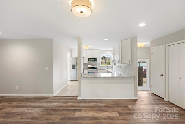 2666 Providence Dr, Gastonia, NC 28052 - kitchen with appliances with stainless steel finishes, light wood-style flooring, white cabinetry, a sink, and light stone countertops