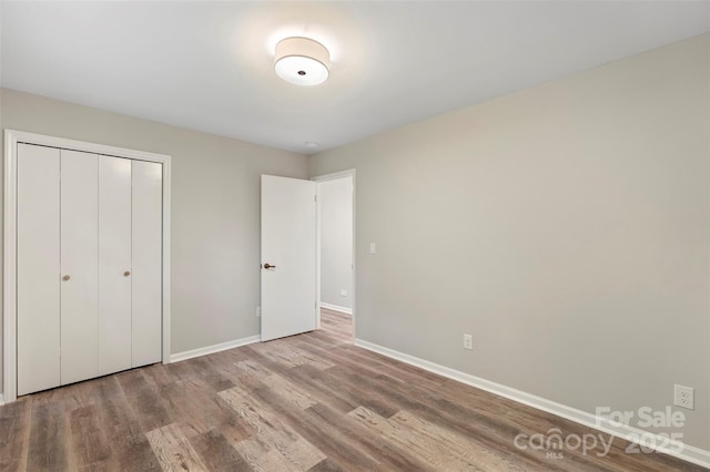 2666 Providence Dr, Gastonia, NC 28052 - unfurnished bedroom with wood finished floors, baseboards, and a closet