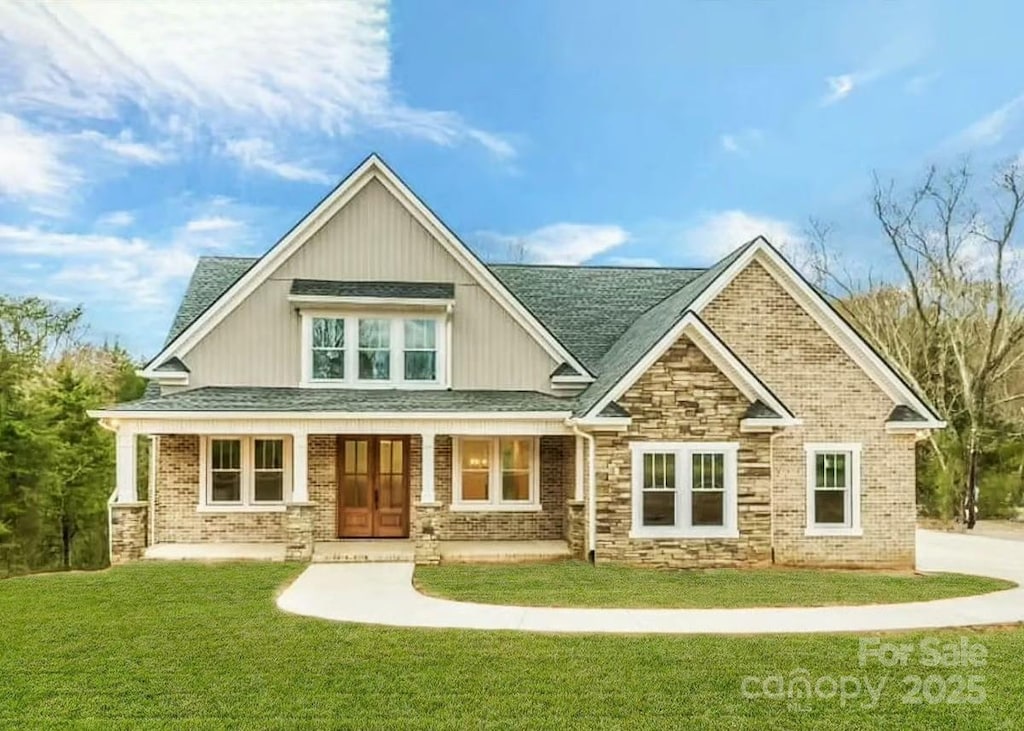 208 Cross Creek Dr, Cherryville, NC 28021 - rear view of house featuring a yard, a shingled roof, stone siding, and covered porch