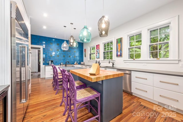 1801 E 8th St, Charlotte, NC 28204 - kitchen with butcher block counters, appliances with stainless steel finishes, a sink, light wood finished floors, and recessed lighting