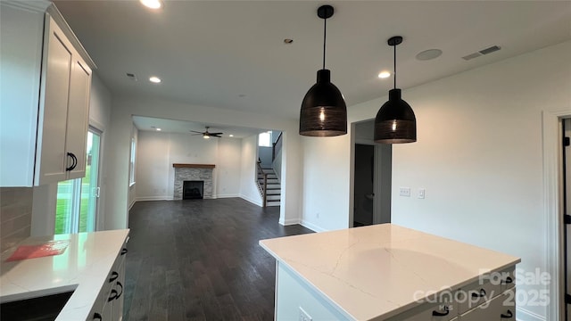 102 Cartington Way Unit Haf0042, Mooresville, NC 28115 - kitchen featuring a fireplace, dark wood-style floors, recessed lighting, a kitchen island, and light stone countertops