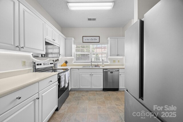 740 Tavern Ct Unit 7, Rock Hill, SC 29732 - kitchen with stainless steel appliances, a sink, white cabinets, stone finish flooring, and a textured ceiling