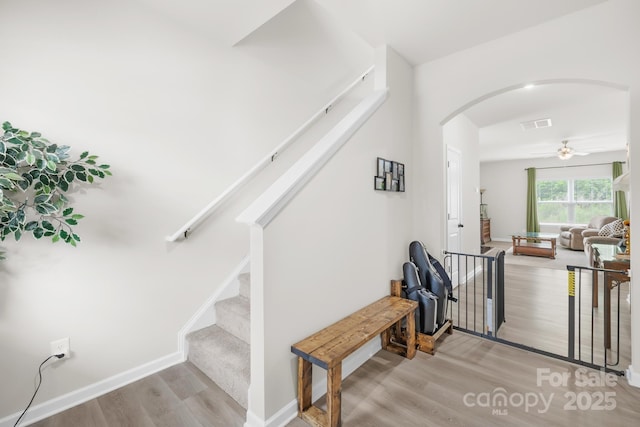5204 Belstone Ln, Charlotte, NC 28215 - stairs with arched walkways, wood finished floors, a ceiling fan, and baseboards