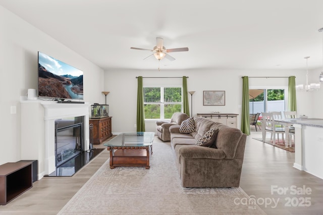 5204 Belstone Ln, Charlotte, NC 28215 - living area with light wood-style floors, a ceiling fan, a fireplace with flush hearth, and plenty of natural light