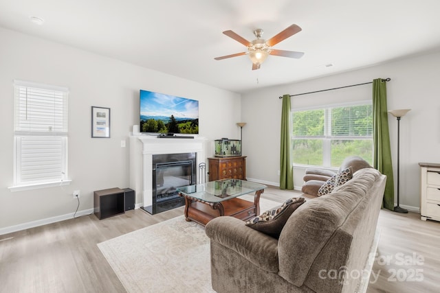 5204 Belstone Ln, Charlotte, NC 28215 - living area with light wood finished floors, a ceiling fan, a glass covered fireplace, and baseboards