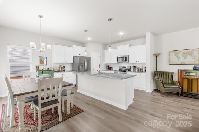 5204 Belstone Ln, Charlotte, NC 28215 - kitchen featuring stainless steel appliances, light wood-style floors, a chandelier, white cabinets, and recessed lighting