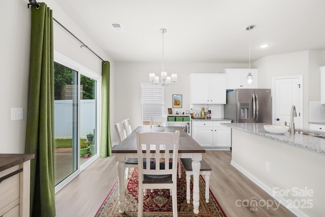 5204 Belstone Ln, Charlotte, NC 28215 - dining space featuring light wood-style flooring, a chandelier, and recessed lighting