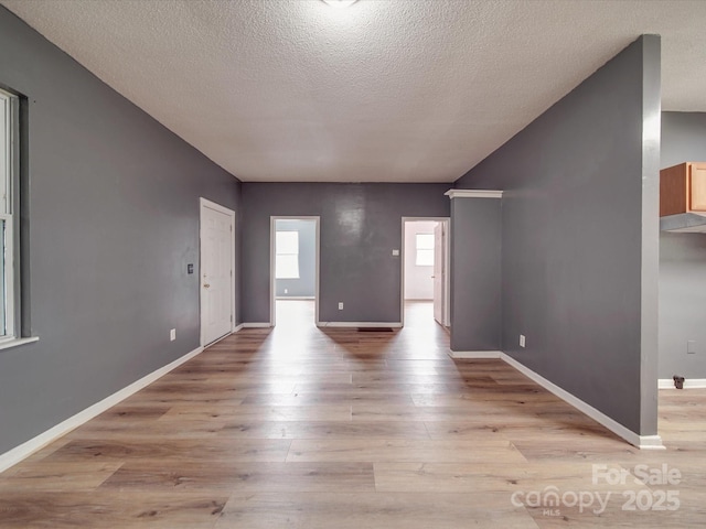 2440 Myers St, Gastonia, NC 28056 - unfurnished living room with a textured ceiling, light wood finished floors, and baseboards