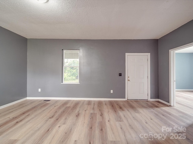 2440 Myers St, Gastonia, NC 28056 - unfurnished room with light wood-style flooring, baseboards, and a textured ceiling