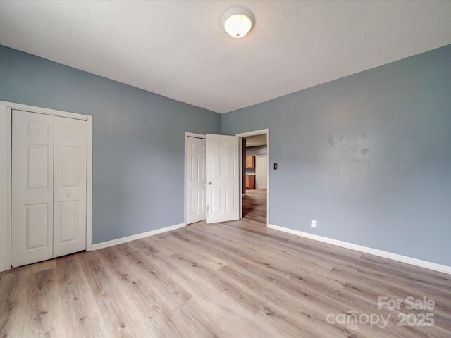 2440 Myers St, Gastonia, NC 28056 - unfurnished bedroom featuring baseboards, light wood-style floors, and multiple closets